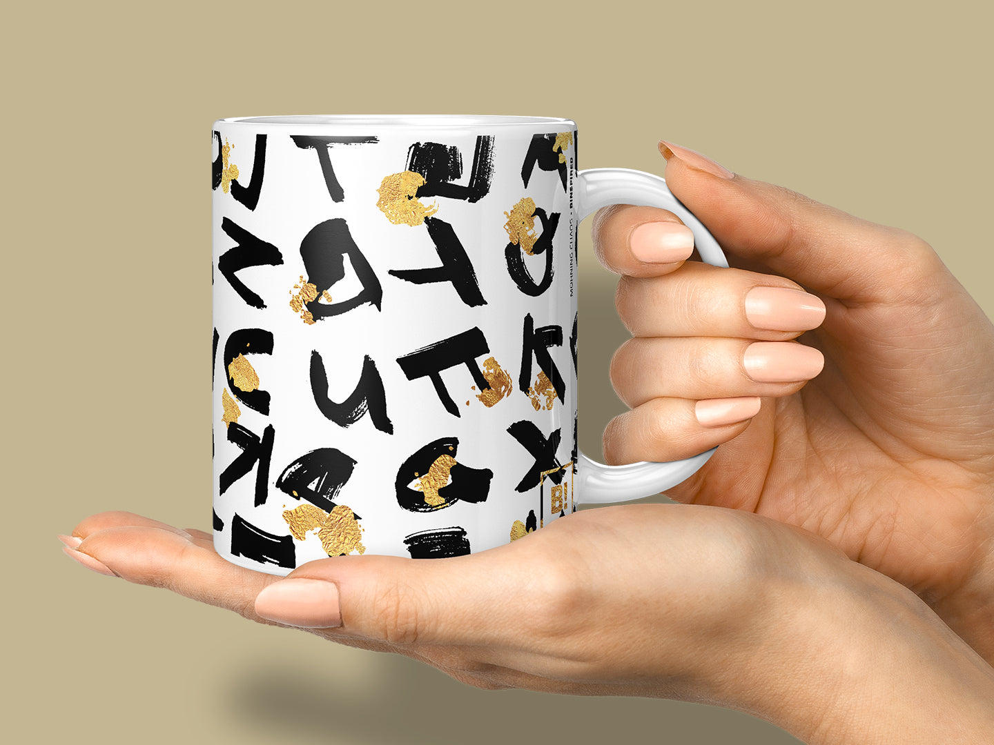 Hand holding a stylish BINSPIRED coffee mug against a warm, earthy neutral background, showcasing the curated collection of empowering and creative designs.
